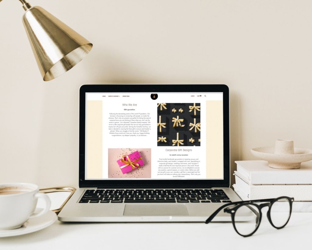 laptop with gold lamp and glasses on desk